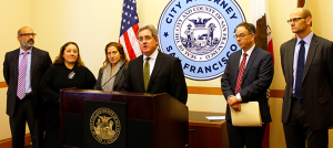 City Attorney Dennis Herrera speaks at a Jan. 16, 2015 news conference after an S.F. Superior Court ruling holds that the ACCJC engaged in “significant unlawful practices” in its evaluation of City College of San Francisco. From left to right: Chief Deputy City Attorney Ron Flynn; Deputy City Attorneys Yvonne Meré and Sara Eisenberg; Herrera; and Deputy City Attorneys Tom Lakritz and Matthew Goldberg.